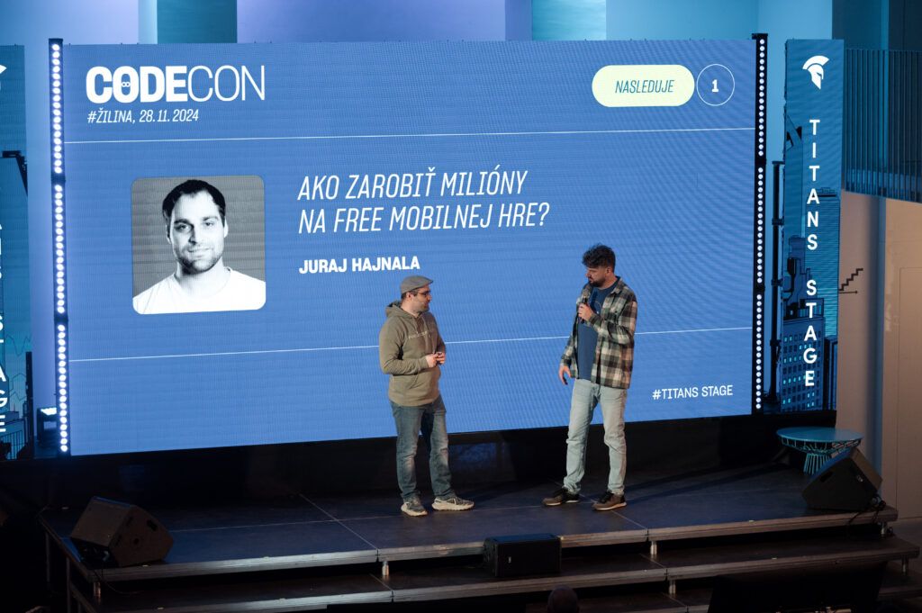 Juraj Hajnala, TITANS' speaker, opened CODECON Žilina 2024 with a presentation for freelancers. He is standing on the stage with event host Ján Gordulič.