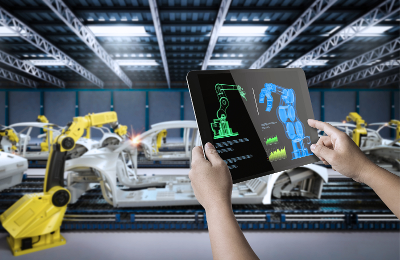 A man is using a tablet to demonstrate the process of using automation to build cars. The significant use of AI, ML and RPA is one of the predicted IT outsourcing trends.