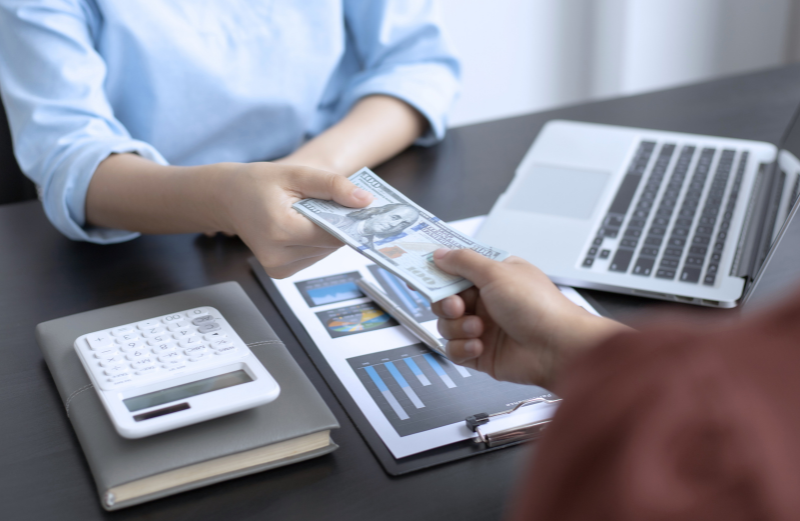 A company representative delivers an employee's paycheck. In our article, we explain how much a programmer earns.